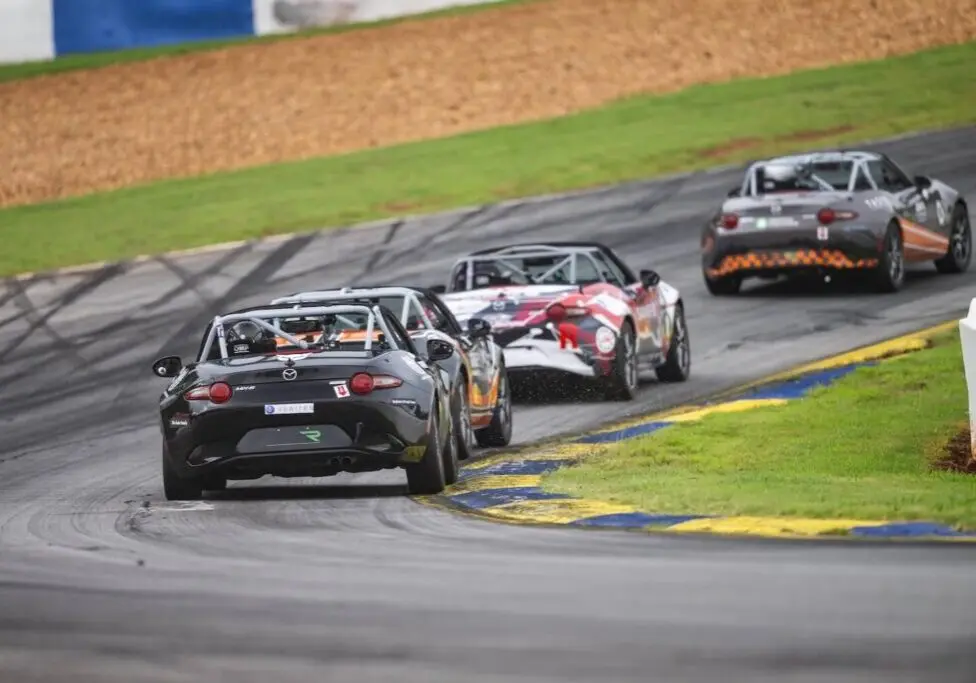 Collegiate race cars running together on track